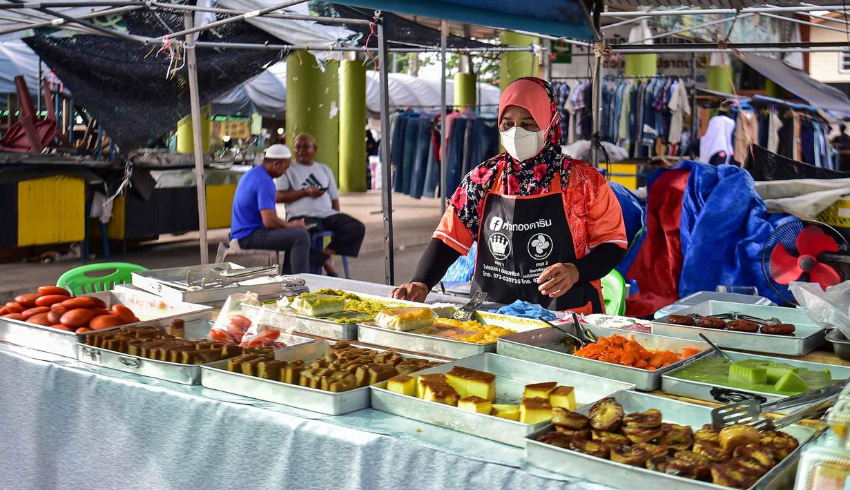 Sebagaimana ditetapkan secara resmi oleh kantor Chularatchamontri (pemimpin umat Islam Thailand), hari pertama bulan suci Ramadan 1447 Hijriah jatuh pada Kamis 19 Februari 2026. Tampak dalam foto, seorang pedagang kaki lima yang menjual makanan untuk berbuka puasa mendirikan lapaknya pada hari pertama bulan suci Ramadan 1447 Hijriah di sebuah pasar di provinsi Narathiwat, Thailand selatan, pada Kamis 19 Februari 2026. (Madaree TOHLALA/AFP)