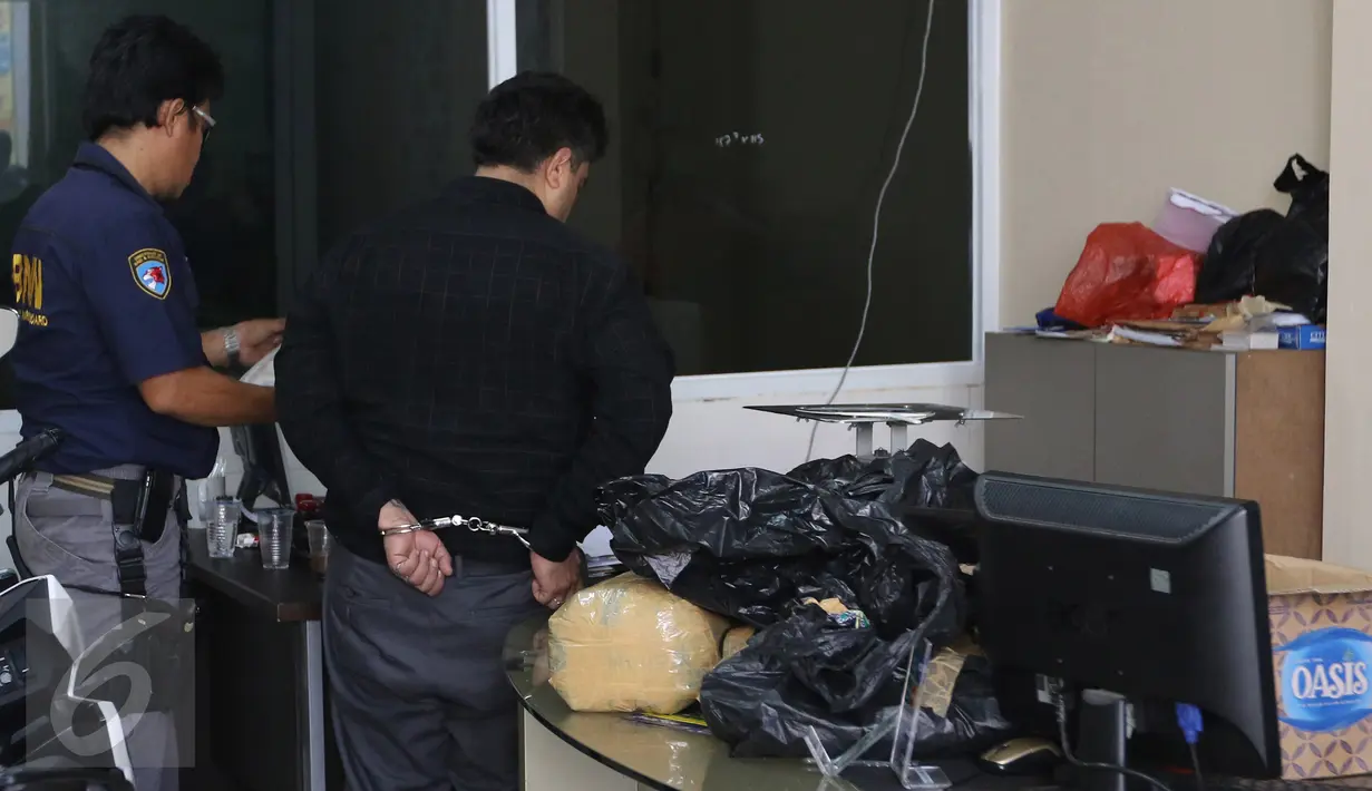 Petugas BNN memeriksa sabu yang dibungkus plastik hitam hingga beberapa kantong saat penggerebekan sebuah hotel di Tanah Abang, Jakarta, Jumat (29/1). Diduga penggerebekan terkait pengembangan kasus sabu 100 kg di Jepara. (Liputan6.com/Herman Zakharia)