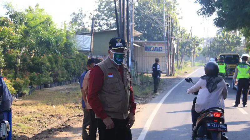 Petugas berjaga di titik check point PSBB di Kota Bekasi. (Liputan6.com/Bam Sinulingga)