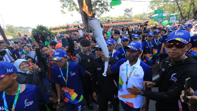 Legenda sepak bola Indonesia, Alexander, menjadi pembawa obor api Asian Games 2018 pada pawai di Bandung, Sabtu (11/8/2018). (Bola.com/Muhammad Ginanjar)