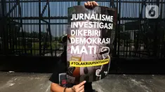 Salah satu pewarta membentangkan poster saat aksi penolakan terhadap revisi Rancangan Undang-Undang (RUU) Penyiaran di depan Gedung Kompleks Parlemen (MPR/DPR/DPD), Jakarta, Senin (27/5/2024). (Liputan6.com/Helmi Fithriansyah)