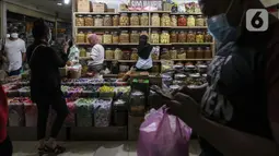 Calon pembeli memilih berbagai jenis kue kering yang dijual di Pasar Mayestik, Jakarta, Senin (3/5/2021). Omzet penjualan kue kering menjelang Lebaran tahun ini mengalami peningkatan hingga 70 persen dari tahun sebelumnya yang mengalami penurunan hingga 70 persen. (Liputan6.com/Johan Tallo)