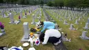 Warga Korea Selatan Lee Myung-ja dan Lee Young-sook (bawah) membungkuk di depan nisan saudara mereka Lee Sun-woo yang gugur saat Perang Korea pada peringatan Hari Pahlawan di Pemakaman Nasional Seoul, Seoul, Korea Selatan, Senin (6/6/2022). (AP Photo /Ahn Young-joon)