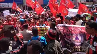 Ratusan Persipura Mania kompak mengenakan busana serba merah saat aksi damai di halaman Kantor DPR Papua, Selasa (26/5/2015). Aksi ini sempat membuat kemacetan panjang. (Liputan6.com / Katharina Janur)