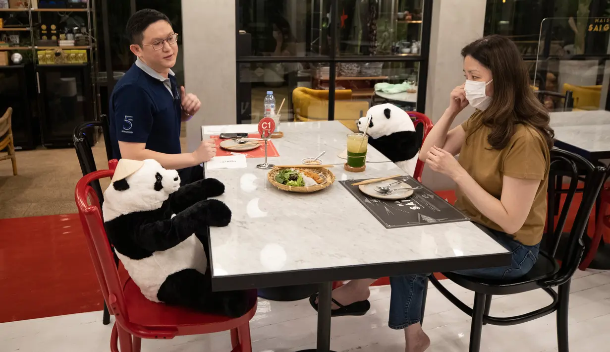 Pelanggan duduk di sebelah boneka panda untuk menjaga jarak di restoran Maison Saigon di Bangkok, Rabu (13/5/2020). Pemerintah Thailand sudah memberlakukan pelonggaran lockdown atau pembatasan wilayah sehingga sejumlah restoran dan toko-toko dapat beroperasi kembali seperti biasa. (AP/Sakchai Lalit)
