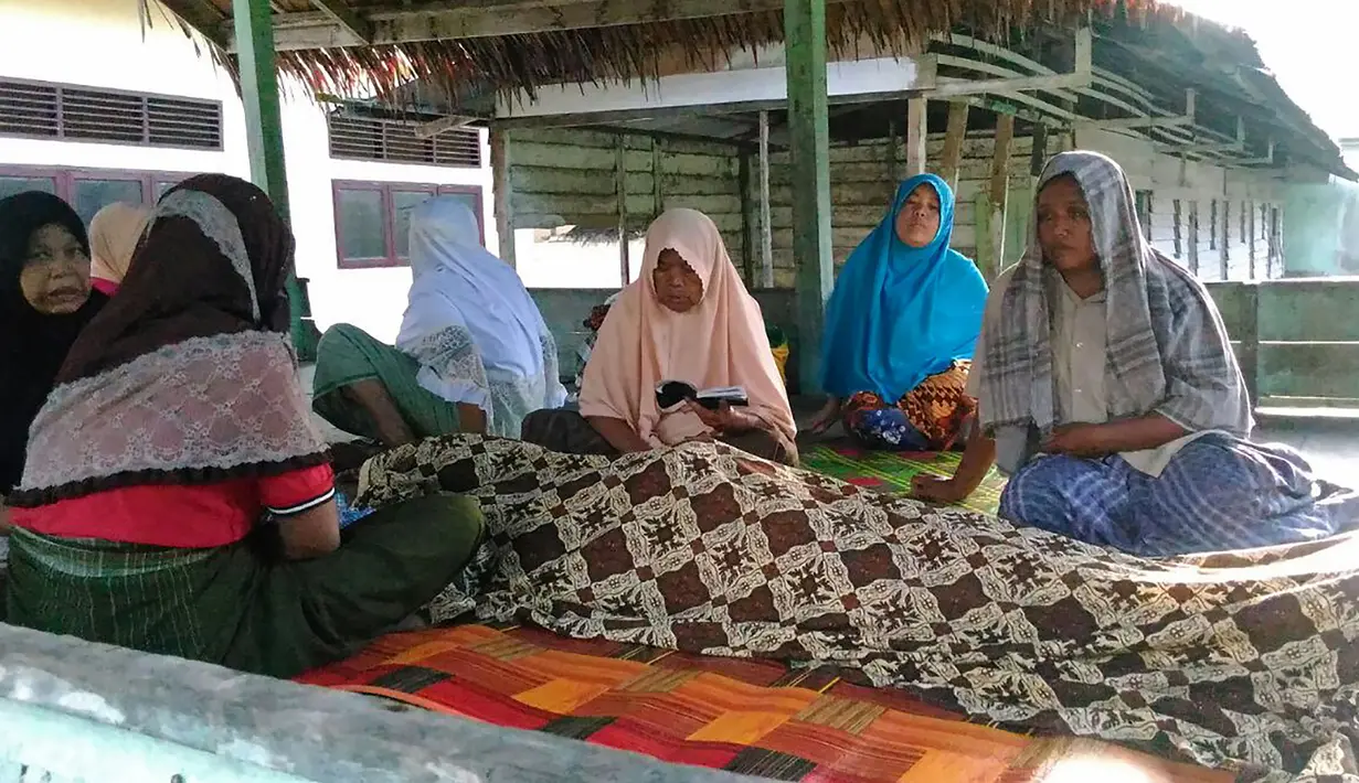 Kerabat memanjatkan doa di dekat jenazah korban gempa 6,4 SR yang mengguncang Kabupaten Pidie Jaya, Aceh, Rabu (7/12). Empat orang meninggal dunia dan sekitar 30 warga mengalami luka-luka akibat tertimpa bangunan roboh. (Zian Muttaqien/AFP)