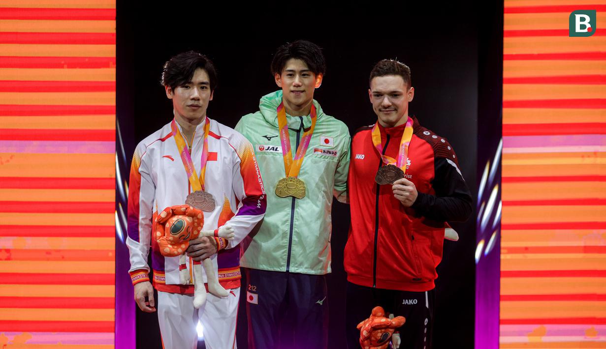 Pesenam Jepang, Daiki Hashimoto (tengah) berfoto bersama dengan pesenam China, Zhang Boheng (kiri) dan pesenam Swiss, Noe Seifert (kanan) saat podium All-Around Kejuaraan Dunia Gimnastik 2025 di Indonesia Arena, Senayan, Jakarta, Rabu (22/10/2025). (Bola.com/Bagaskara Lazuardi)