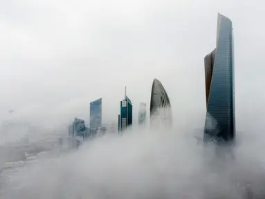 Foto udara ini memperlihatkan gedung-gedung tinggi saat pagi berkabut di Kota Kuwait pada Selasa (14/3/2023). Kemunculan kabut memperlihatkan pemandangan indah, dimana kota Kuwait terlihat seperti negeri di atas awan. (Photo by Yasser Al-Zayyat / AFP)
