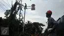 Seorang petugas memperhatikan rekannya yang sedang menebang pohon di sepanjang jalan DI. Panjaitan, Kebon Nanas, Jakarta, Senin (21/3). Penebangan pohon-pohon itu untuk pelebaran jalan terkait pembangunan Jalan Tol Becakayu. (Liputan6.com/Gempur M Surya)