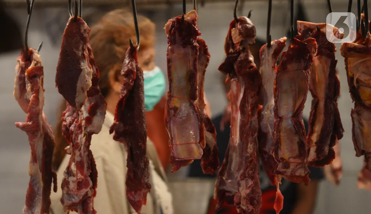 Deretan daging sapi tergantung di lapak pedagang di Pasar Perumnas, Jakarta, Selasa (19/1/2021). Biasanya, harga daging sapi berada di kisaran Rp 110 ribu sampai Rp 114 ribu per kilogram. (merdeka.com/Imam Buhori)