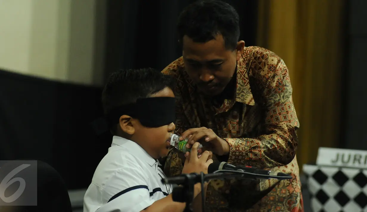 Jefri Setiawan minum disela-sela bernyanyi sambil memainkan keyboard di Auditorium  Kemenpora, Jakarta, Kamis (14/11). Jefri akan memainkan 50 lagu selama 5 jam nonstop dengan mata  tertutup. (Liputan6.com/Helmi Fithriansyah)