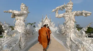 Biksu saat melakukan tur di Wat Rong Khun atau kuil putih di Provinsi Chiang Mai, Thailand, Jumat (4/3). Kuil Putih dirancang oleh seniman visual Thai Chalermchai Kositpipat. (REUTERS / Jorge Silva)