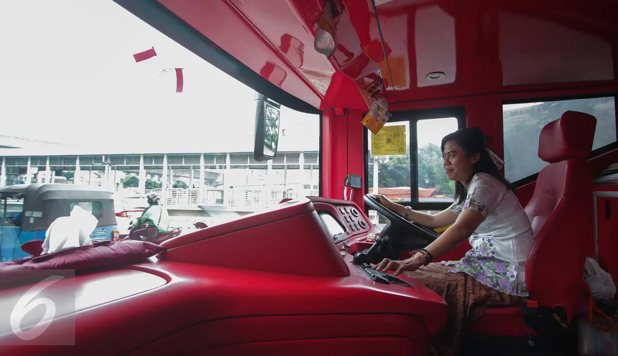 Pramudi bus tingkat wisata TransJakarta mengenakan kebaya saat menjalankan tugasnya di Jakarta, Jumat (21/4). Dalam rangka Hari Kartini, semua pramudi perempuan bus pariwisata dan Transjakarta mengenakan kebaya. (Liputan6.com/Faizal Fanani)