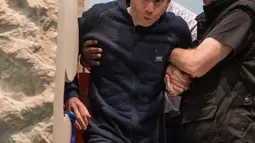 Seniman asal Perancis, Abraham Poincheval dikeluarkan dari dalam sebuah batu di Museum Paris, Prancis, Rabu (1/3). Ia berhasil menuntaskan tantangan tinggal seminggu dalam batu dan keluar dalam keadaan lemah. (AP Photo/Zacharie Scheurer)