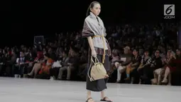 Model membawakan busana karya para perancang yang tergabung dalam Kopikkon pada Indonesia Fashion Week 2018 di JCC, Jakarta, Sabtu (31/3). Kopikkon merupakan bagian dari pengembangan ekonomi kreatif nasional bentukan Bekraf. (Liputan6.com/Faizal Fanani)