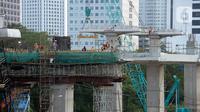 Para pekerja sedang menyelesaikan bentangan beton panjang light rail transit (LRT) di tikungan Jembatan 66 Kuningan-Dukuh Atas, Jakarta, Senin (6/7/2020). (merdeka.com/Dwi Narwoko)