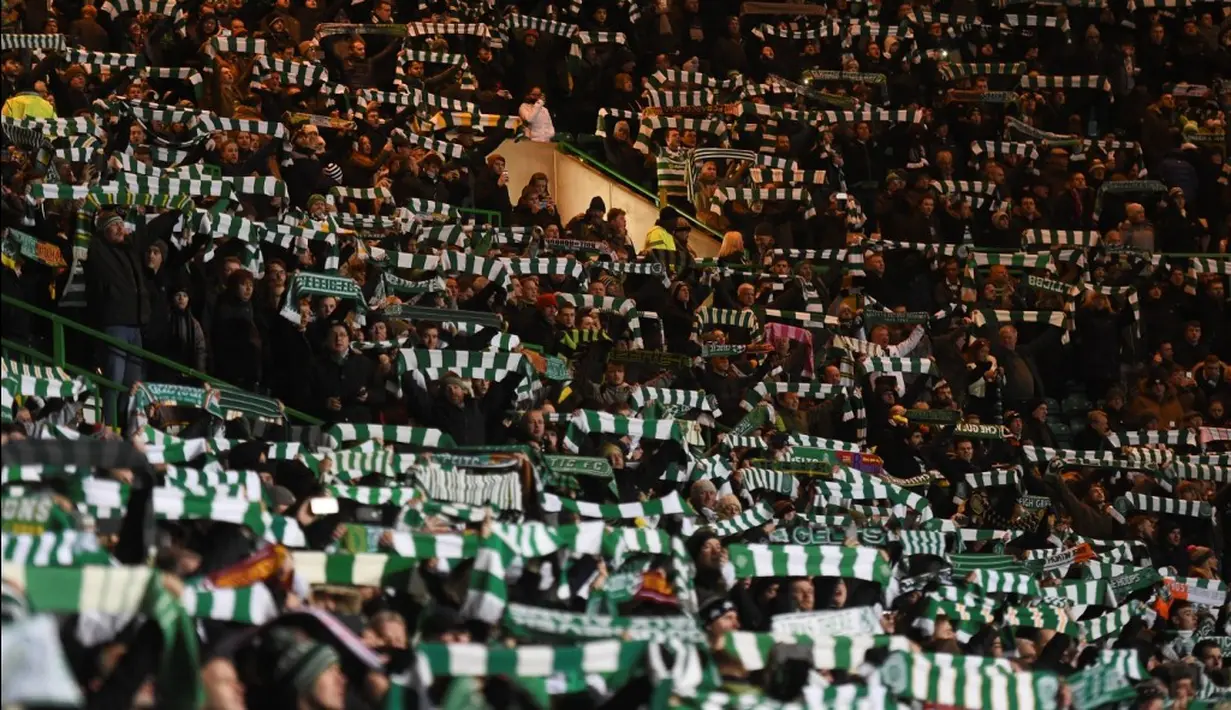 Aksi suporter Celtic saat menjamu Barcelona pada laga kelima Grup C Liga Champions di Celtic Park, Rabu (23/11/2016). (AFP/Paul Ellis)