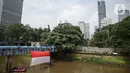 Sejumlah relawan membentangkan bendera Merah Putih di aliran kali
Ciliwung di kawasan Sudirman, Jakarta, Minggu (22/8/2021). Pembentangan atau pengibaran bendera Merah Putih tersebut dilaksanakan untuk memperingati HUT ke-76 RI. (Liputan6.com/Faizal Fanani)