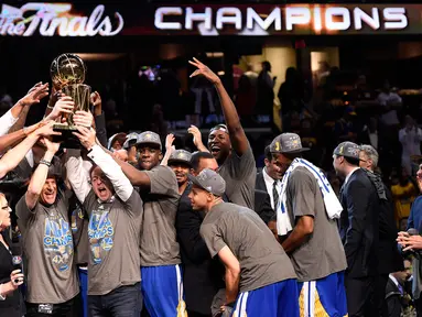 Para Pemain Golden State Warriors mengangkat trofi usai mengalahkan Cleveland Cavaliers di pertandingan ke enam final NBA di Quicken Loans Arena,  Cleveland, (17/6/2015). Warriors unggul atas Cavaliers 4-2 dalam format best of seven. (Reuters/Bob Donnan)