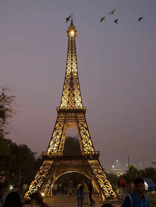 Pengunjung memandang replika Menara Eiffel di sebuah taman umum di New Delhi, 4 Februari 2020. Barang-barang bekas seperti besi batangan, suku cadang mobil dan pipa dimanfaatkan untuk membuat tujuh keajaiban dunia yang ikonis di taman umum itu yang sukses menarik banyak pengunjung (Xinhua/Javed Dar)