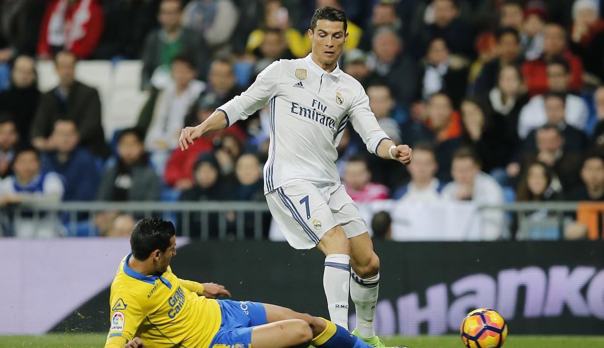 Bintang Real Madrid, Cristiano Ronaldo (kanan) berusaha melewati hadangan pemain Las Palmas, Vicente Gomez pada lanjutan La Liga Spanyol di Santiago Bernabeu stadium, Madrid, (1/3/2017). Madrid bermain imbang 3-3. (AP/Paul White)