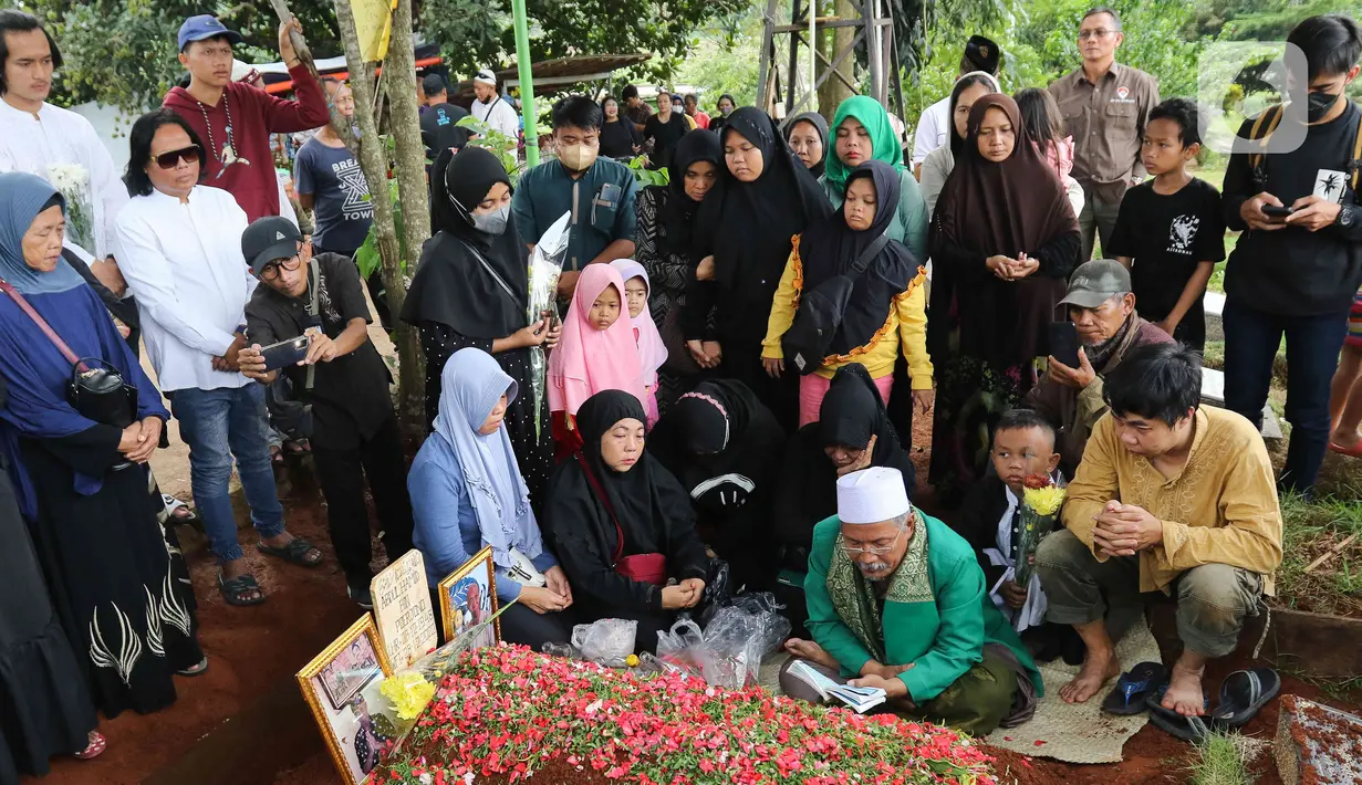 Keluarga dan kerabat berdoa saat pemakaman Abdul Hamid alias Pak Ogah di TPU (Tempat Pemakaman Umum) Jatisari, Bekasi, Jawa Barat, Kamis (29/12/2022). Pak Ogah salah satu pengisi suara dalam serial film Si Unyil meninggal pada (28/12/2022) di usia 74 tahun. (Liputan6.com/Herman Zakharia)