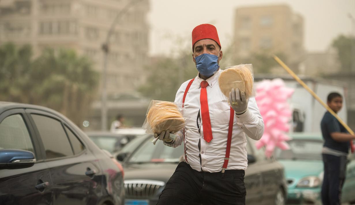 Seorang pedagang asongan yang mengenakan masker terlihat di sebuah jalan di Kairo, Mesir, pada 5 April 2020. Mesir pada Sabtu (4/4) melaporkan lima kematian baru akibat infeksi COVID-19, menjadikan total kasus kematian di negara tersebut mencapai 71. (Xinhua/Wu Huiwo)