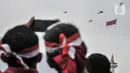 Warga menyaksikan manuver helikopter TNI AU membawa bendera Merah Putih saat perayaan HUT ke-77 Republik Indonesia (RI) di Taman Aspirasi Monumen Nasional (Monas), Jakarta Pusat, Rabu (17/8/2022).  Aksi akrobatik pesawat tempur dan helikopter yang membawa bendera Merah Putih tersebut disambut antusias oleh warga yang datang untuk mengikuti upacara Kemerdekaan RI. (merdeka.com/Iqbal S Nugroho)