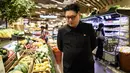 Howard X yang mirip Kim Jong-un mencari buah di supermarket di Hong Kong (7/6). Howard X telah menjadi terkenal karena kemiripannya dengan pemimpin Korut Kim Jong-un sedang mempersiapkan untuk penampilannya di Singapura. (AFP Photo/Anthony Wallace)