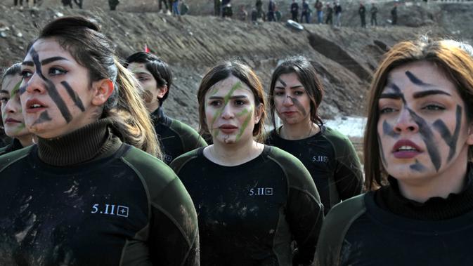 Pasukan perempuan Peshmerga berbaris saat berlatihan dalam upacara kelulusan di Kota Soran, Irak, Rabu (12/2/2020). Latihan militer pasukan bersenjata Kurdi tersebut dilakukan sekitar 100 kilometer timur laut ibu kota otonomi wilayah Kurdi di Irak, Arbil. (SAFIN HAMED/AFP)