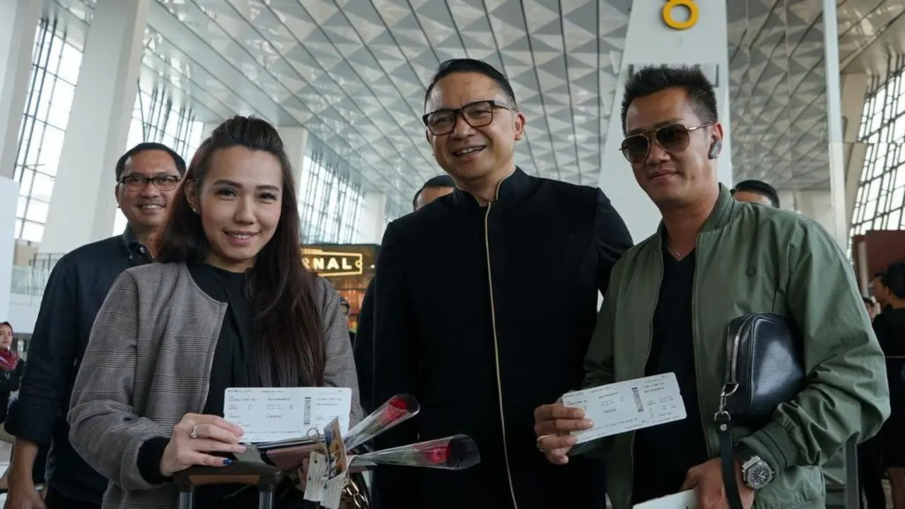 Peringati Hari Pelanggan Nasional, Garuda Indonesia, membagikan souvenir kepada penumpang GA 830 rute Jakarta – Singapura di Terminal 3 Bandara Internasional Soekarno Hatta.
