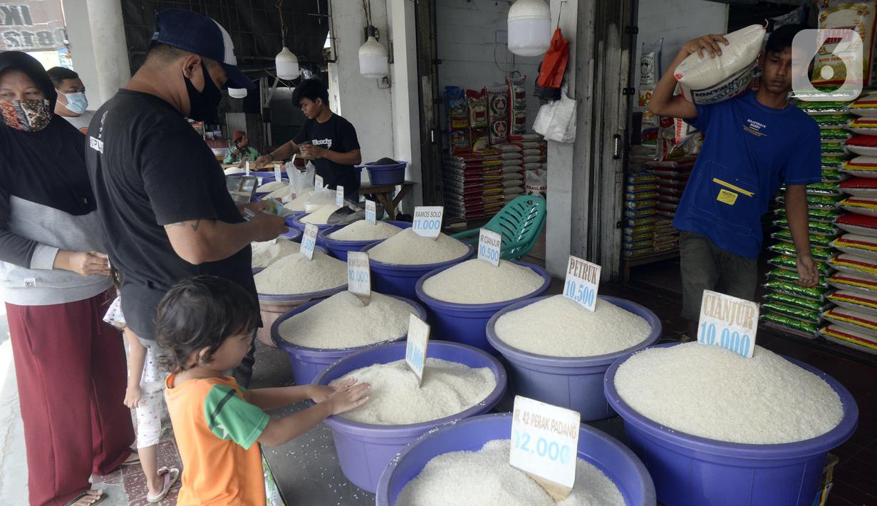 Pedagang beras melayani pembeli di pinggir Jalan Raya Pamulang, Tangerang Selatan, Banten, Jumat (11/12/2020). Jelang Natal dan Tahun Baru 2021, harga beras dipasaran masih normal tidak ada kenaikan. (merdeka.com/Dwi Narwoko)
