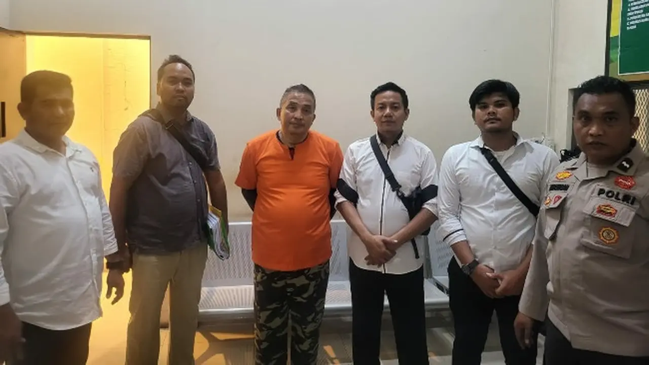 Tersangka penipuan investasi Rp25 miliar (baju oranye) bersama penyidik Reskrimsus Polda Riau.