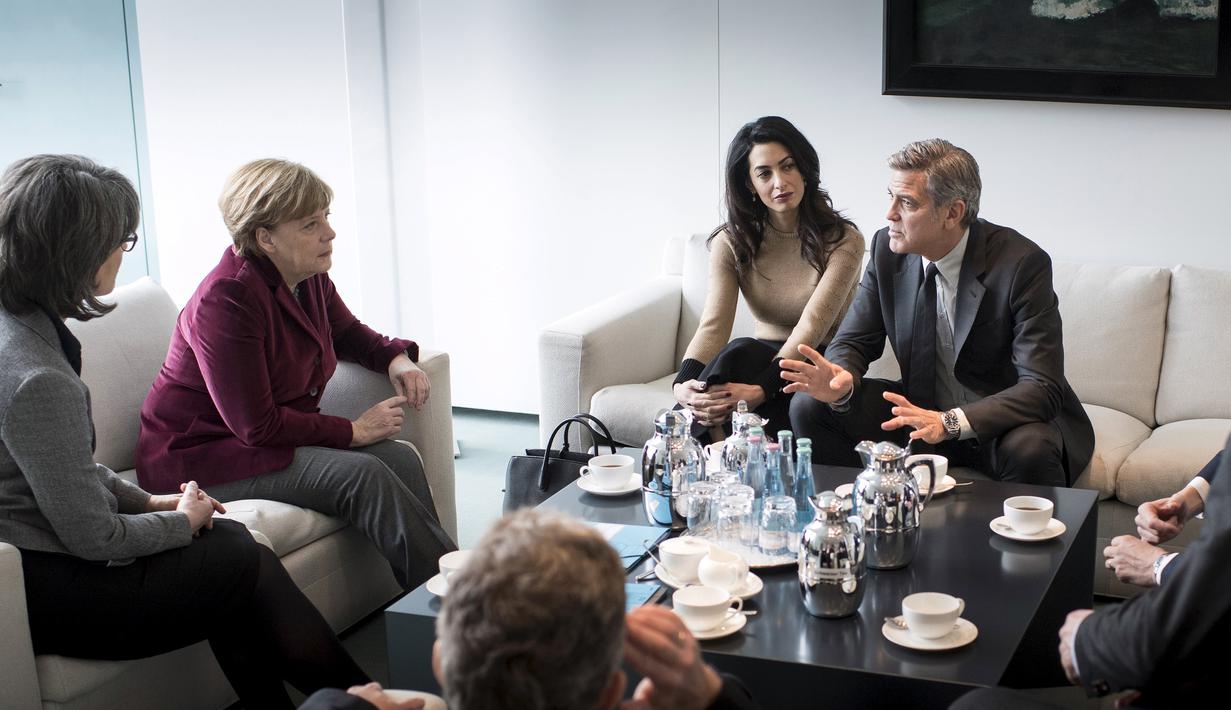 Aktor AS, George Clooney dan istrinya, Amal Alamuddin saat menemui Kanselir Jerman, Angela Merkel (kedua kiri) di Berlin, Jerman, Jumat (12/2). Pertemuan keduanya guna membahas krisis pengungsi di Eropa. (REUTERS/Bundesregierung/Guido Bergmann)