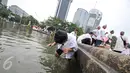 Seorang anak mengambil air wudhu memanfaatkan air di kolam Putaran Patung Kuda, Jakarta, Jumat (4/11). Sebagian massa demonstan gelar salat Jumat di area Bundaran Patung Kuda. (Liputan6.com/Yoppy Renato)