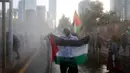 Seorang pria membentangkan bendera Palestina saat unjuk rasa memprotes kebijakan Presiden AS, Donald Trump soal Yerusalem sebagai ibu kota Israel di luar Kedubes AS di Santiago, Chile, (11/12). (AP Photo / Luis Hidalgo)