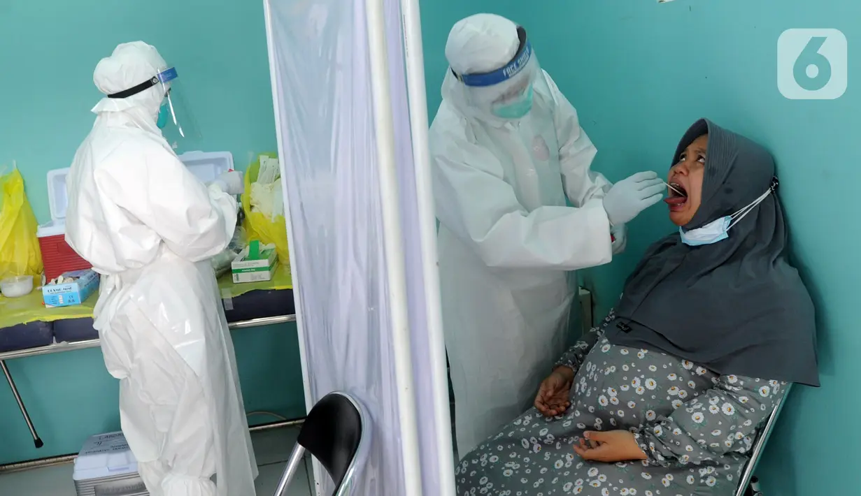 Paramedis melakukan swab test PCR kepada warga di Puskesmas Kramat Jati, Jakarta Timur, Rabu (13/1/2020). Setiap harinya, Puskesmas Kramat Jati menyediakan kuota 300 swab test PCR  secara gratis untuk memutus mata rantai penyebaran COVID-19. (merdeka.com/Arie Basuki)