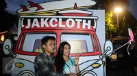 Dua orang pengunjung berfoto di salah satu stand di JakCloth 2015 di Parkir Timur Senayan Jakarta, Rabu (30/12/2015). JakCloth 2015 berlangsung pada 30 Desember 2015 hingga 3 Januari 2016. (Liputan6.com/Helmi Fithriansyah)