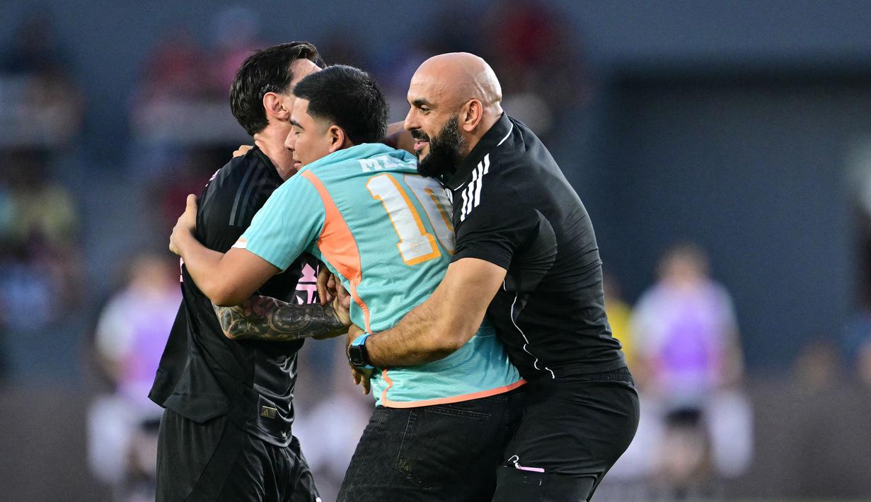 Pengawal Lionel Messi, Yassine Cheuko menangkap seorang penyusup lapangan dalam laga persahabatan antara Inter Miami melawan Sporting San Miguelito di Stadion Romeo Fernandez, Panama, Amerika, Senin (03/02/2025) waktu setempat. (AFP/Martin Bernetti)
