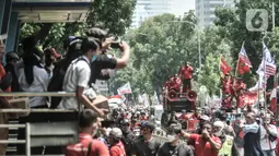 Warga memfoto aksi konvoi massa dari Konfederasi Serikat Buruh Seluruh Indonesia (KSBSI) di Jalan Medan Merdeka Barat, Jakarta, Senin (12/10/2020). Ratusan massa buruh ini hendak berunjuk rasa menolak pengesahan omnibus law Undang-Undang Cipta Kerja di Istana Negara. (merdeka.com/Iqbal S Nugroho)