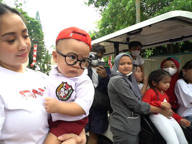 Digendong oleh Nagita Slavina, Rayyanza Malik Ahmad memakai seragam SD lengkap dengan topinya. Bayi yang akrab disapa Cipung ini juga memakai kacamata. (Foto: YouTube/ Rans Entertainment)