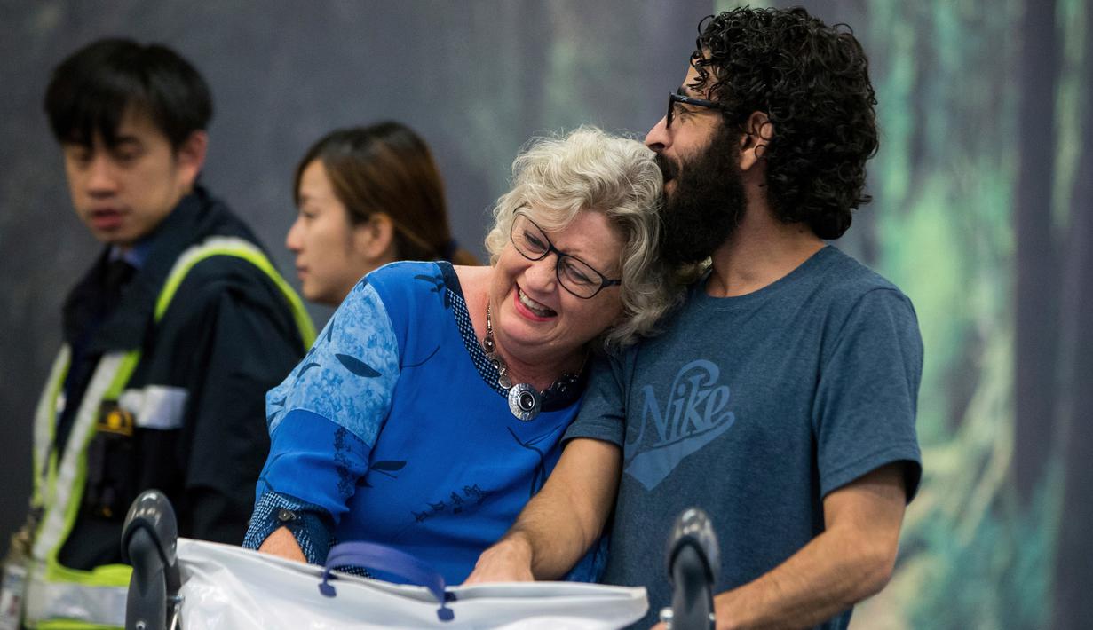 Pria Suriah, Hassan al-Kontar dan sukarelawan Canada Caring Society  tiba di bandara Vancouver setelah terbang dari Kuala Lumpur , Senin (26/11). Dua organisasi mensponsori Kontar datang ke Kanada sebagai pengungsi. (Ben Nelms/The Canadian Press via AP)