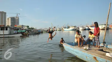 Seorang anak melompat ke laut di kawasan Luar Batang, Penjaringan, Jakarta, Senin (28/3). Pemprov DKI Jakarta menargetkan pembangunan 300 Ruang Publik Terpadu Ramah Anak (RPTRA) di seluruh kawasan Jakarta. (Liputan6.com/Gempur M Surya) 