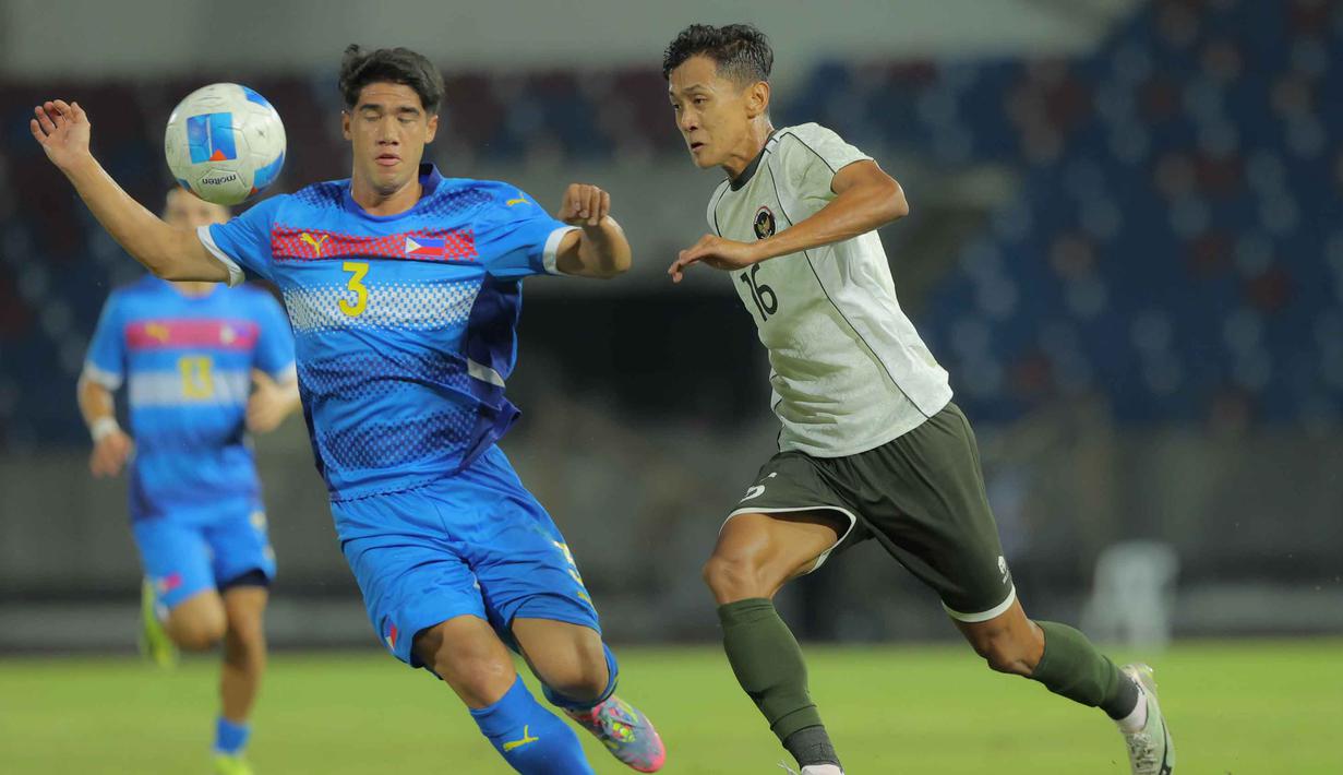 Serangan demi serangan dilancarkan dan sempat merepotkan barisan pertahanan Filipina. Tampak dalam foto, pemain Timnas Indonesia U-22, Rifqi Ray Farandi (kanan) berebut bola dengan pemain Filipina, Gabriel Guimaraes, pada laga perdana Grup C SEA Games 2025 di Stadion 700th Anniversary, Chiang Mai, Thailand, Senin (8/12/2025). (Bola.com/Bagaskara Lazuardi)