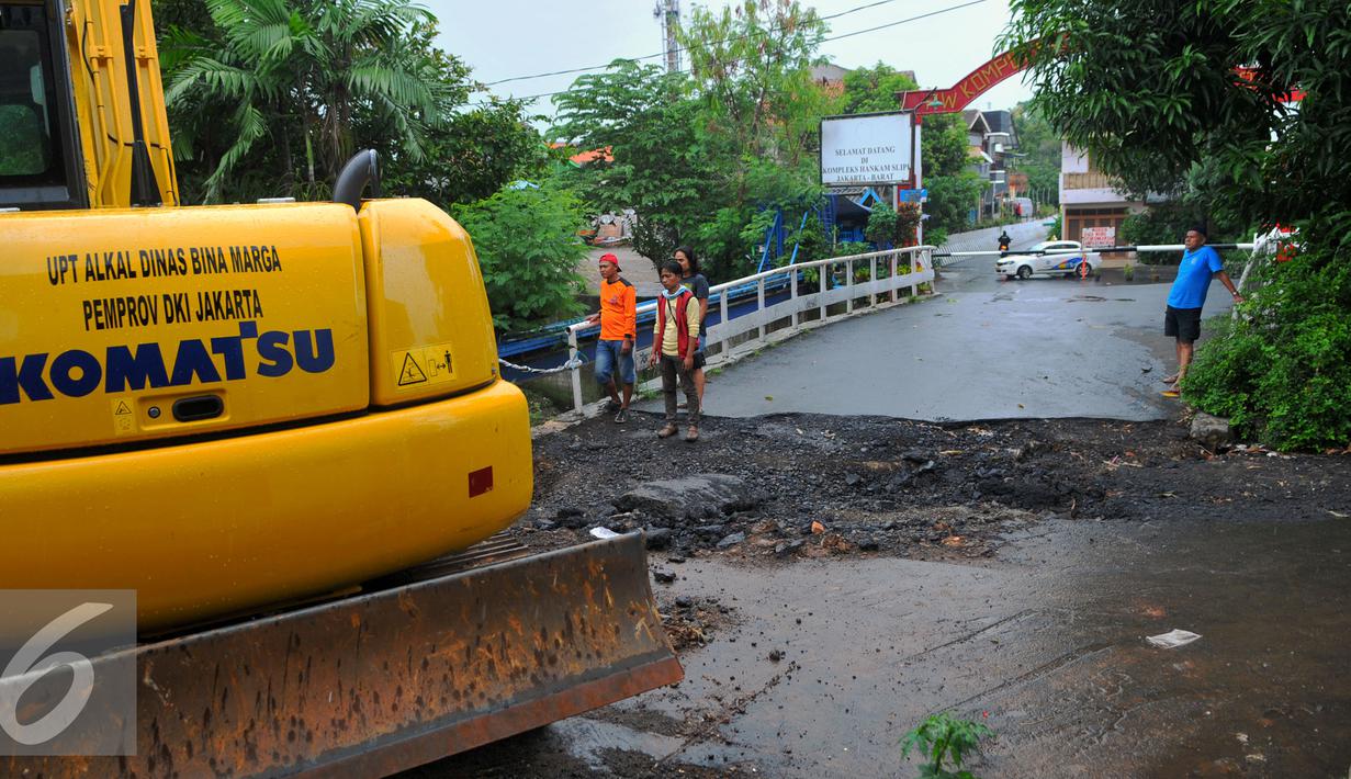 Petugas melakukan perbaikan Jembatan Inspeksi Kali Grogol yang ambles di Komplek Hankam, Slipi, Jakarta, Senin (21/3). Amblesnya jembatan juga akibat pondasi jembatan bergeser dan permukaan jalan amblas. (Liputan6.com/Faisal R Syam)