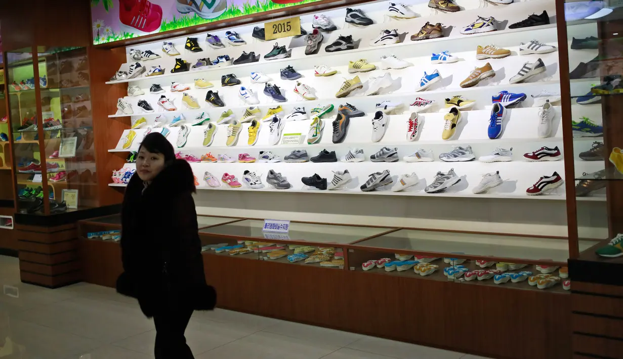 Seorang wanita berdiri di ruang pameran produk di Ryuwon Shoe Factory yang berspesialisasi dalam sepatu olahraga, di Pyongyang, Korea Utara (1/2). (AP Photo/Dita Alangkara)