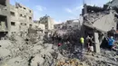 Warga Palestina dan petugas penyelamat terlihat berusaha mencari korban, beberapa menggunakan tangan mereka untuk menggali puing-puing bangunan. (AP Photo/Abdul Qader Sabbah)