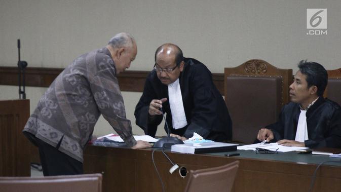 Terdakwa PT Nusa Kontruksi Enjiniring (NKE) diwakili oleh Direktur Utama Djoko Eko Suprastowo berdiskusi dengan kuasa hukum disela menjalani sidang perdana kasus korupsi di Pengadilan Tipikor, Jakarta, Kamis (11/10). (Liputan6.com/Herman Zakharia)