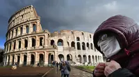 Seorang pria mengenakan masker pelindung melewati Colosseum di Roma, Italia, 7 Maret 2020. Hingga 21 Maret 2013, sebanyak 47.021 orang terinfeksi virus corona COVID-19 di Italia dengan korban meninggal mencapai 4.032 orang. (Photo by Alberto PIZZOLI/AFP)