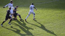 Striker Leeds United, Patrick Bamford, berebut bola dengan pemain Burnley, James Tarkowski, pada laga Liga Inggris di Stadion Elland Road, Minggu (27/12/2020). Leeds United menang dengan skor 1-0. (Laurence Griffiths/Pool via AP)